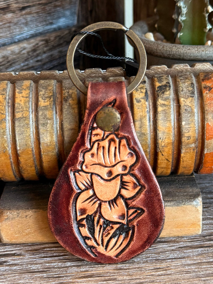 Brown tooled leather keychain with metal ring and embossed hat figure