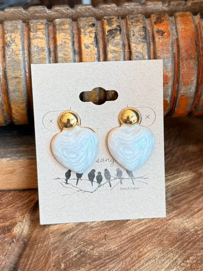 Light blue textured heart stud earrings with gold-tone posts, front view on card.