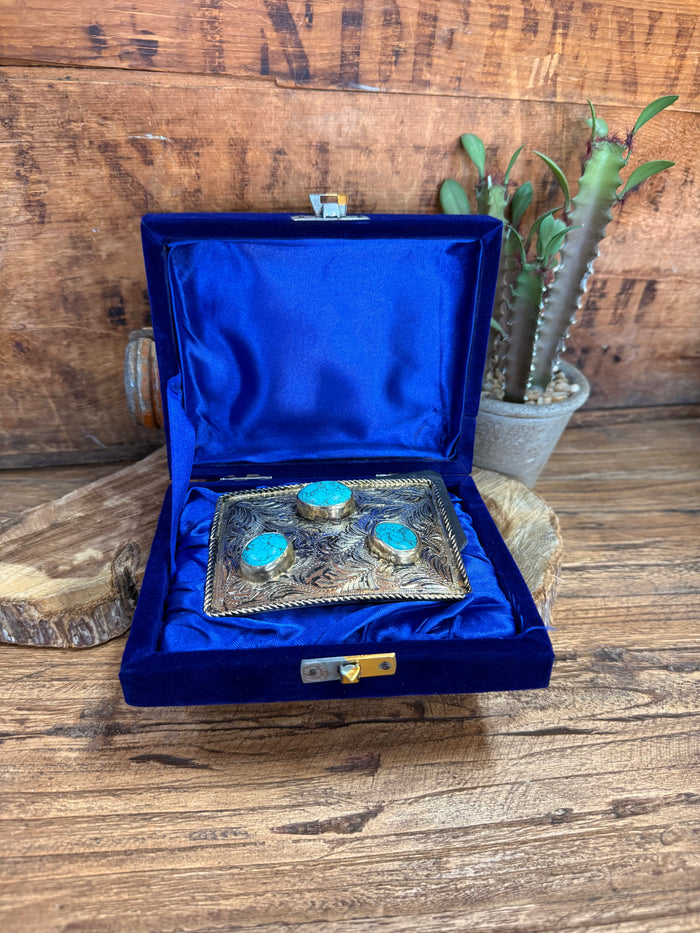 Turquoise stone belt buckle displayed in open blue presentation box with velvet insert