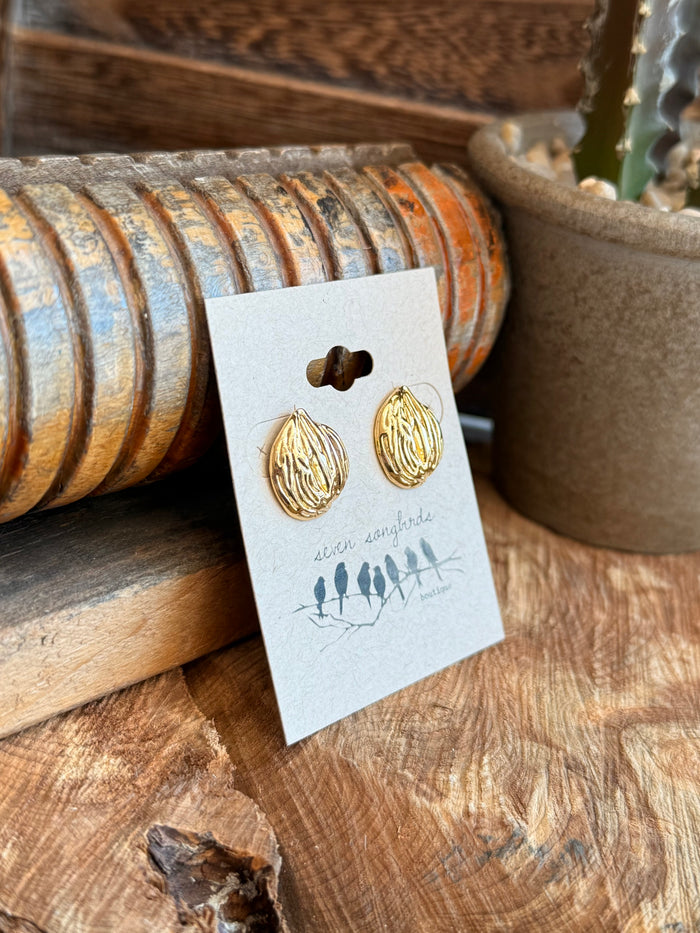 Gold-tone textured round stud earrings with ridged finish on display card