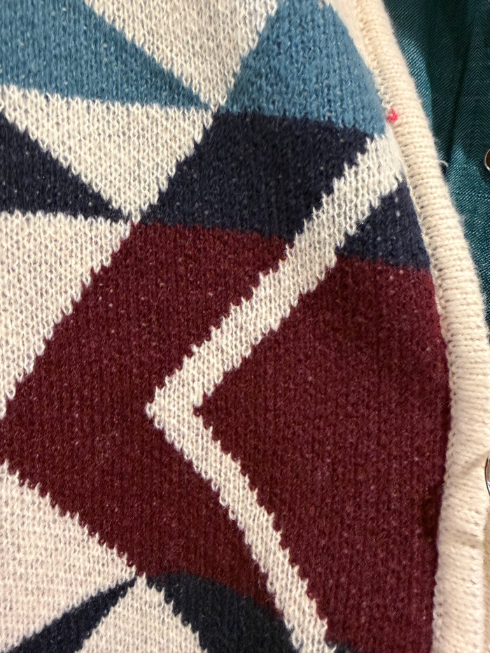 Cream knit zip-front cardigan with geometric aztec pattern in burgundy, navy, and blue