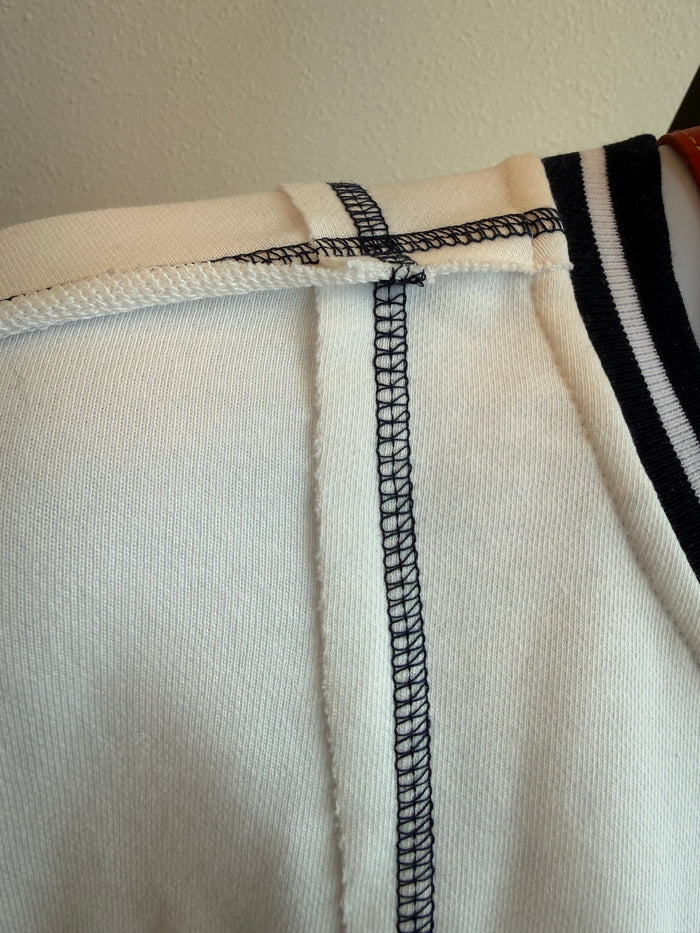 Cream short-sleeve sweatshirt cuff with black-and-white striped trim and stitched hem