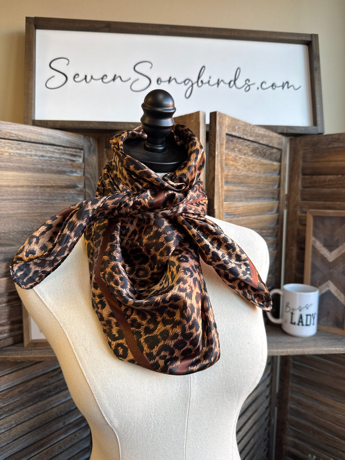 Leopard print wild rag scarf in brown and black, draped on a mannequin