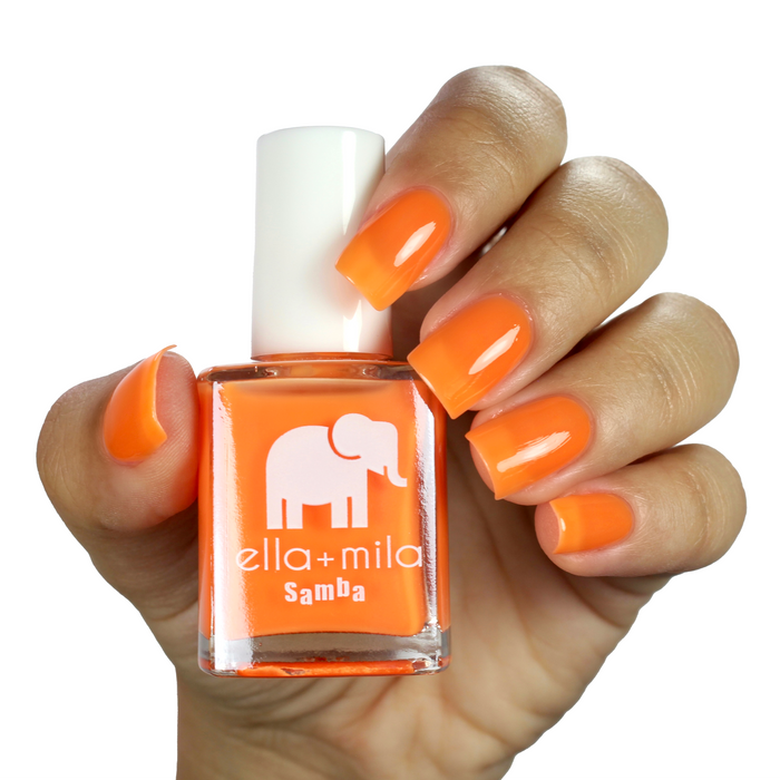 Aperol Spritz neon orange nail polish on a medium skin tone, hand holding the bottle