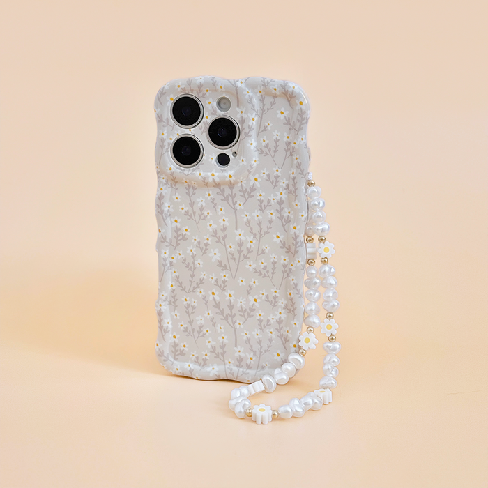 Phone in a floral Coconut Lane case with Daisy Pearl beaded strap on a light peach background.