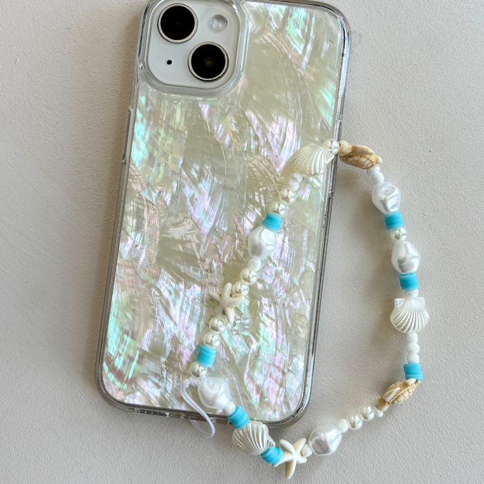 Phone with a pearlescent case and colorful beaded strap on a light background.