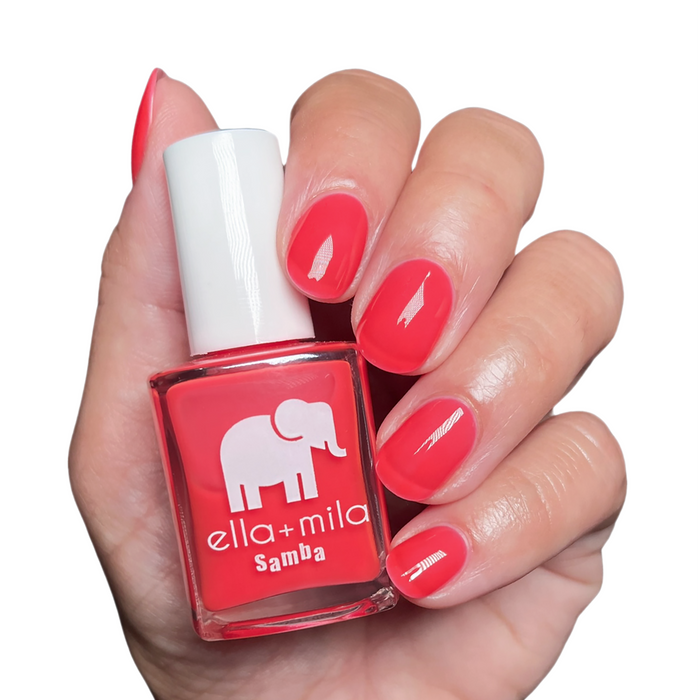 Bellini coral hot pink nail polish manicure on a light skin tone with the bottle