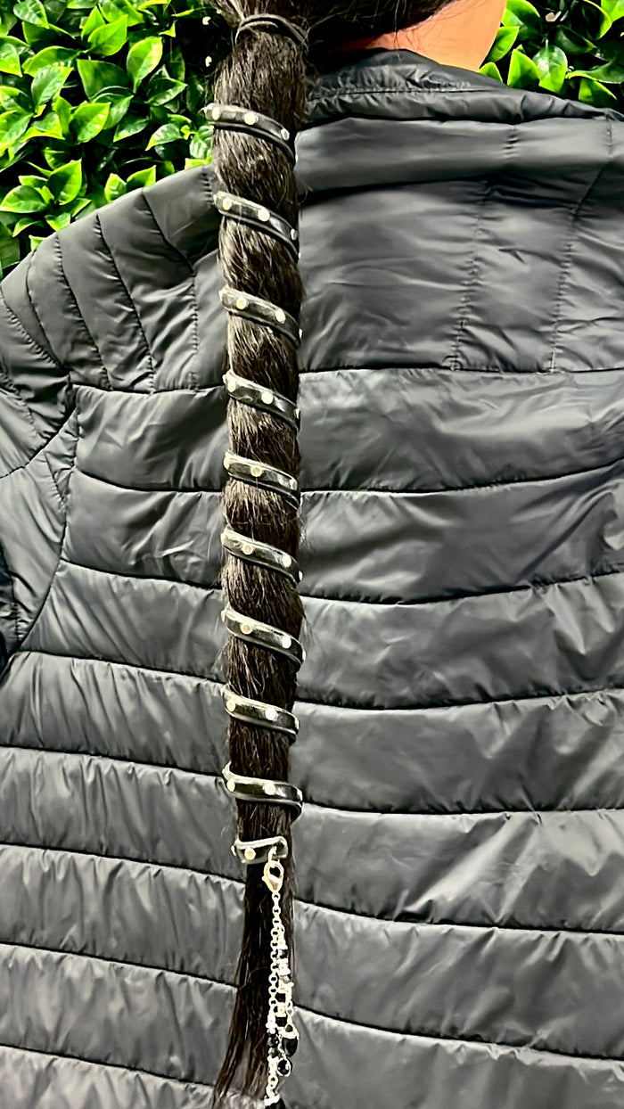 12-inch black leather spiral ponytail wrap with rivets worn on long dark hair, outdoor setting