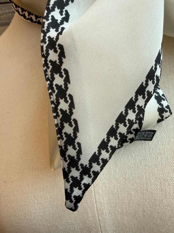 Black and white herringbone twilly scarf close-up with patterned edge and logo tag