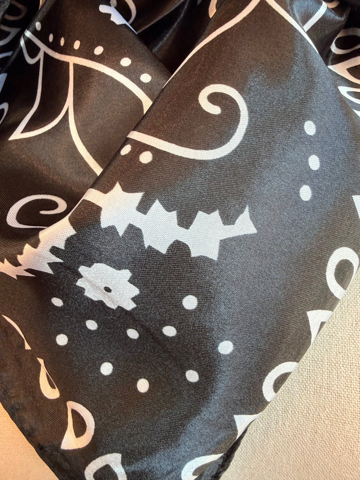 Wild rag scarf corner with black base and white motifs, paisley swirl and dots