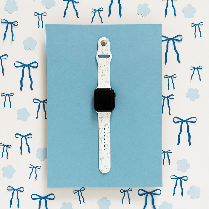 Blue Apple Watch strap with floral and bow patterns.