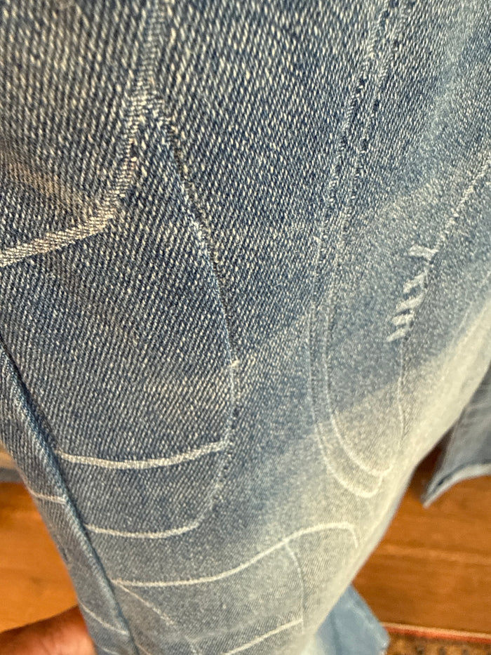 Light blue cuffed jeans close-up: stitched line pattern on denim pocket area