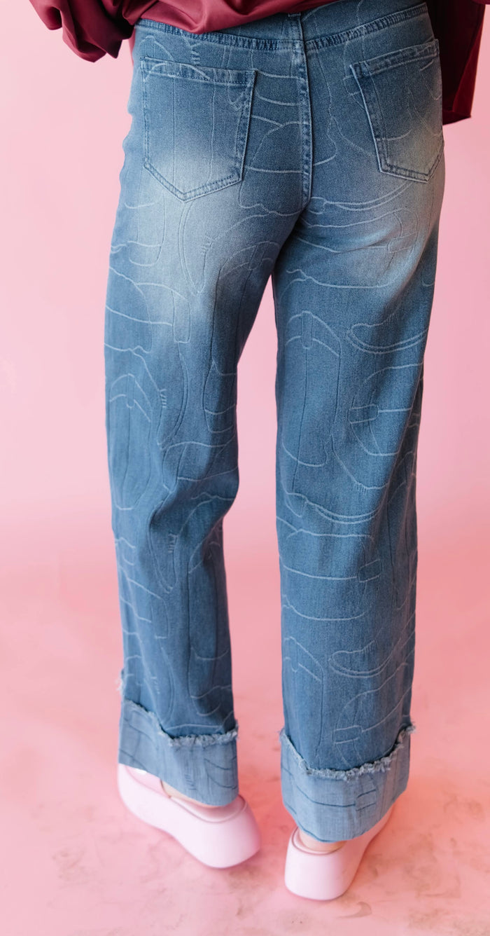 Light blue cuffed jeans with stitched line pattern, mid-rise fit and tapered straight leg