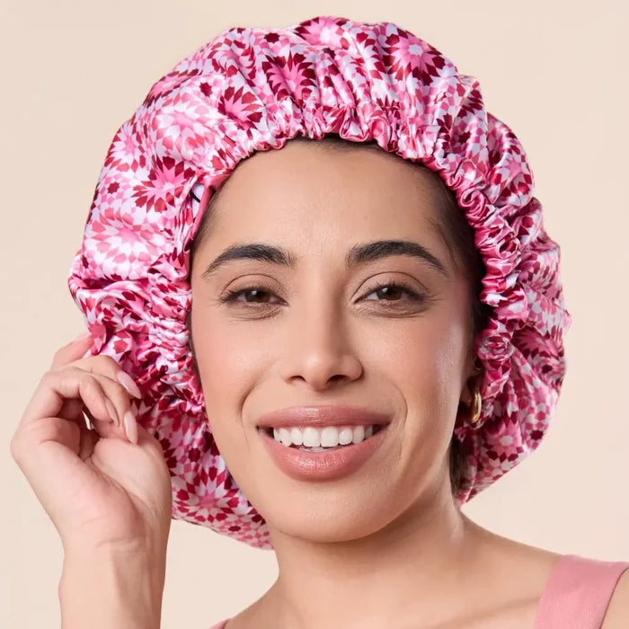 Woman wearing pink floral satin bonnet for curly hair protection