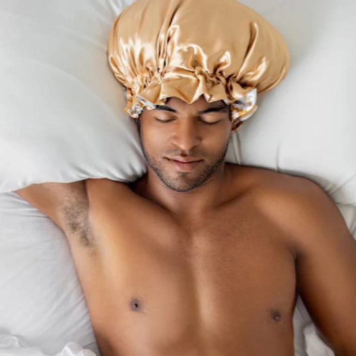 Man sleeping with gold satin bonnet for curly hair protection