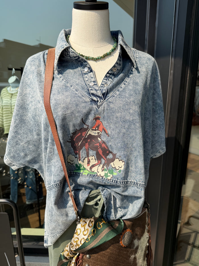 Faded blue denim graphic shirt with short sleeves and chest cowboy-style artwork