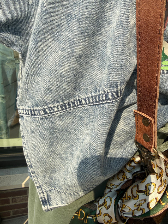 Light-wash denim graphic shirt with stitched hem and visible seam details