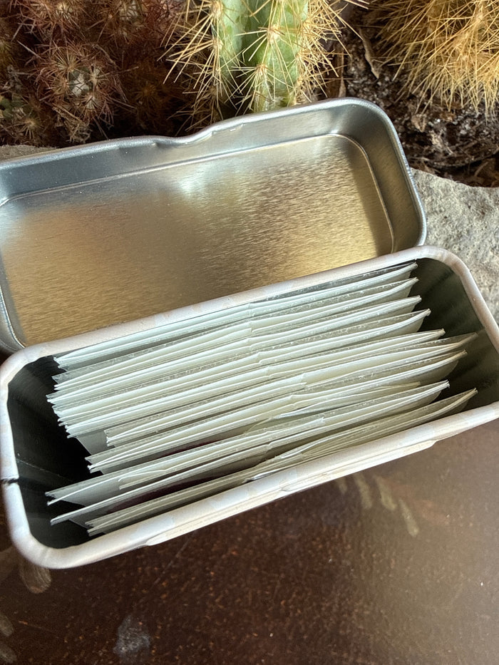 Open metal tin with stacked white equestrian bandage rolls