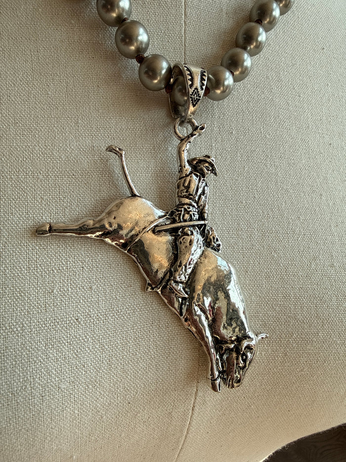 Silver-tone bull rider pendant with bead link chain, detailed close-up