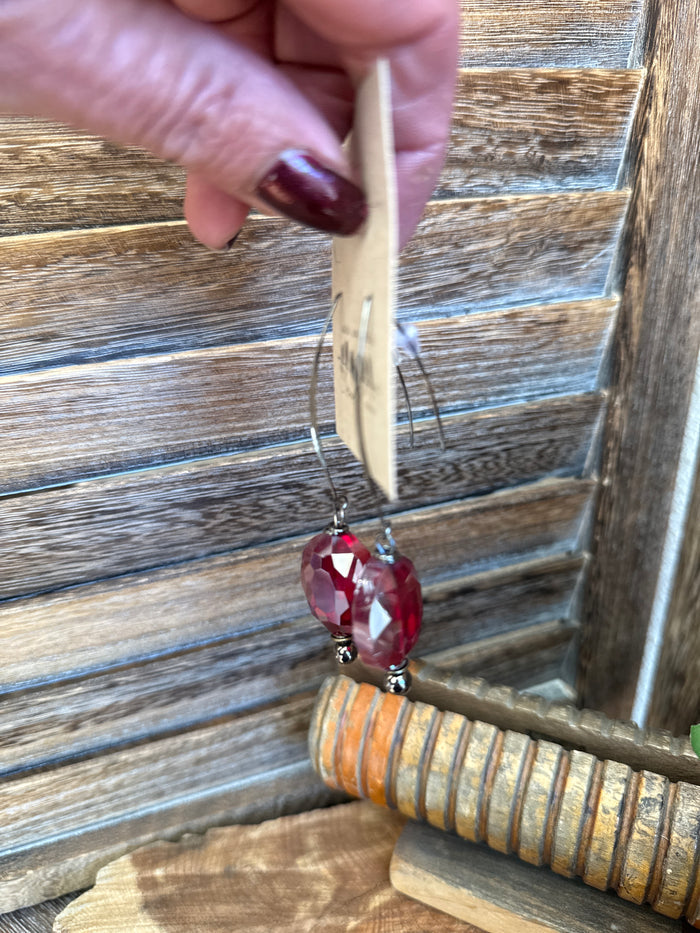 Burgundy faceted teardrop glass bead on kidney wire earring, close-up
