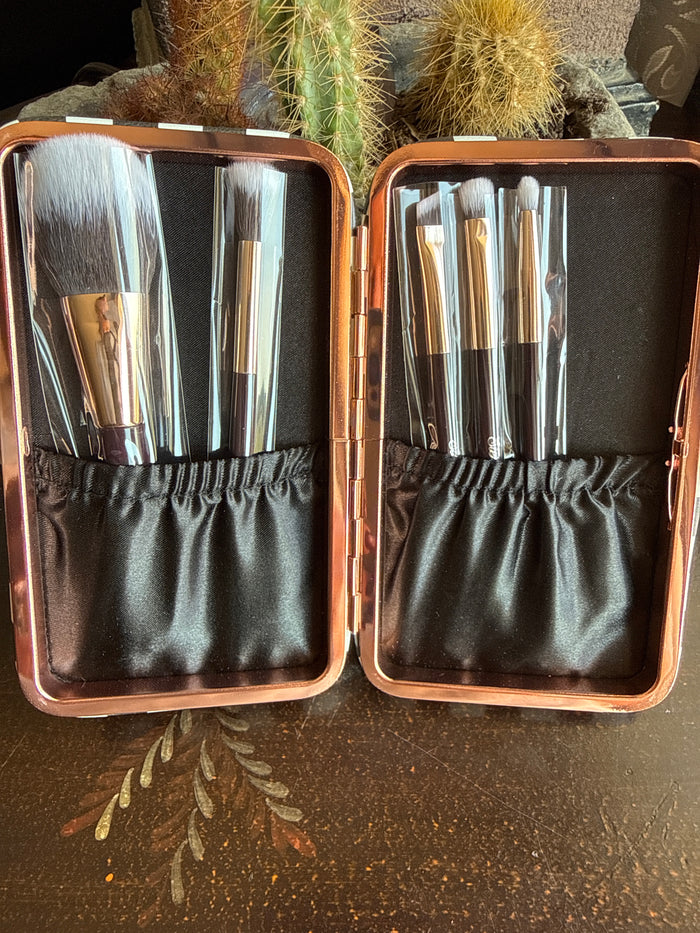 Open checkered makeup brush case with metal brush heads and black fabric slots