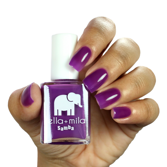 Chicha electric purple nail polish on a medium skin tone, hand holding the bottle