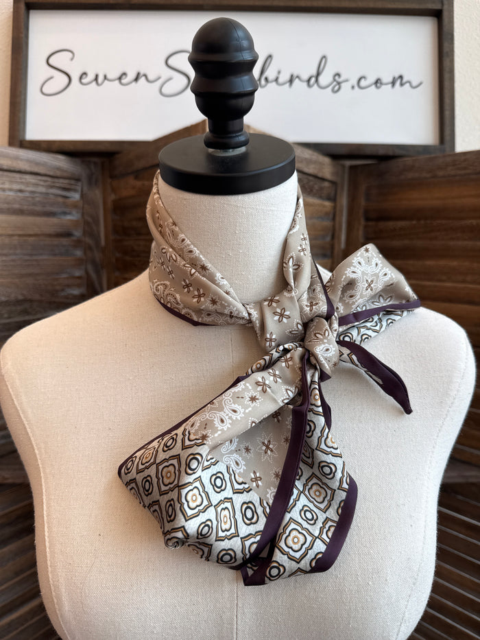 Paisley twilly scarf in chocolate tan, tied in a bow on a mannequin