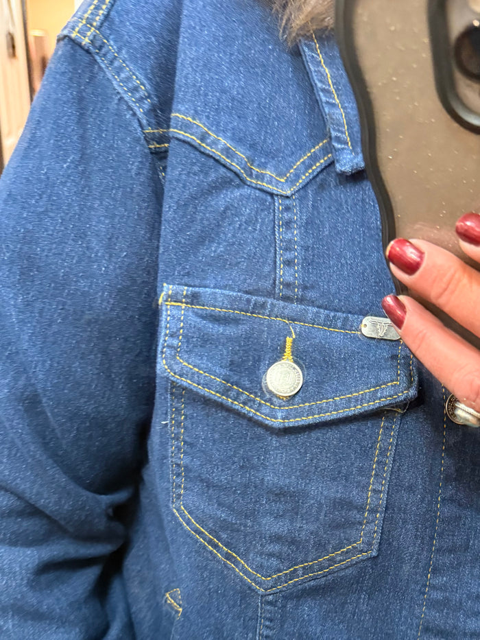 Dark wash denim jacket detail: flap chest pockets, contrast yellow stitching, snap button