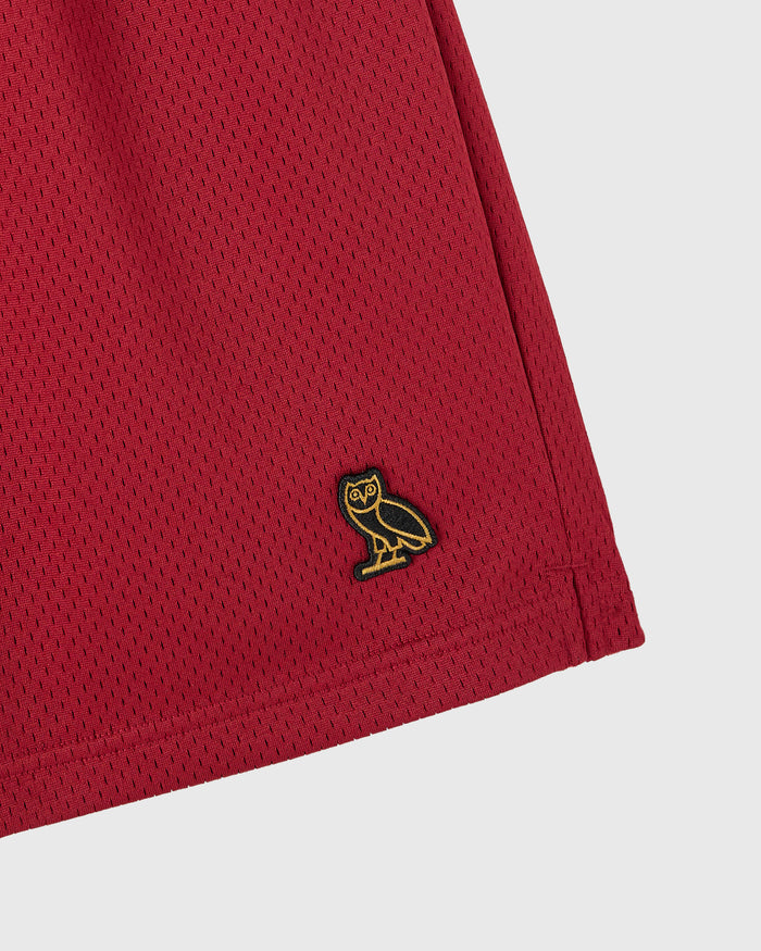 Deep red mesh short with small gold and black owl embroidered logo on leg.