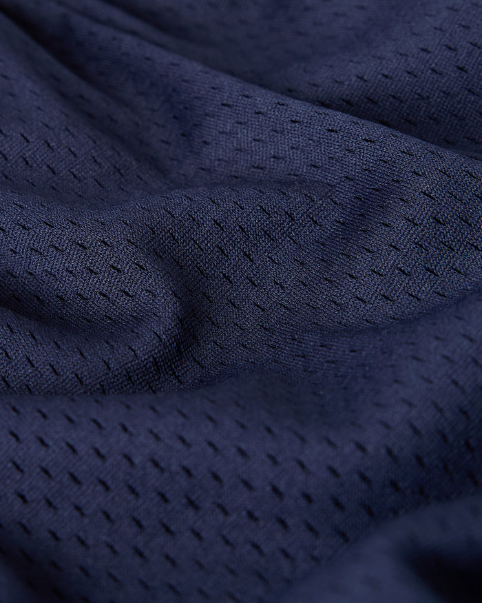 Close-up of navy mesh fabric with textured weave pattern and visible breathable openings.