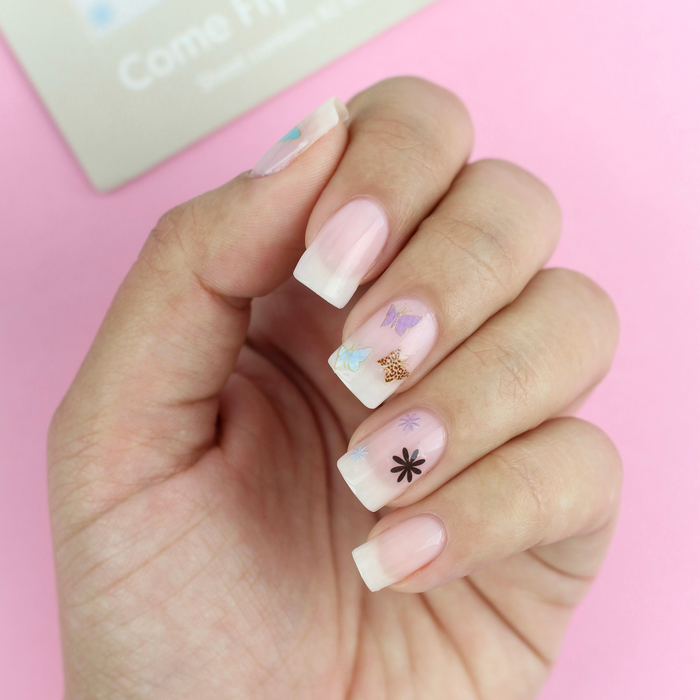 Come Fly With Me butterfly and flower decals on a sheer pink manicure, pink background