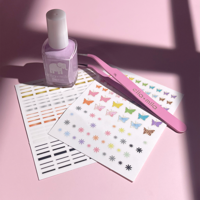 Come Fly With Me nail decal sheets with a lilac nail polish bottle on a pink background
