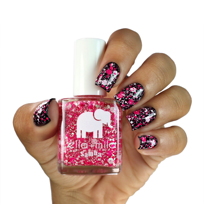Congo Bongo pink confetti glitter layered over black on a medium skin tone, holding the bottle