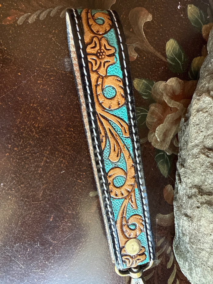 Cowhide wristlet keychain with turquoise floral feather pattern and stitched leather edges