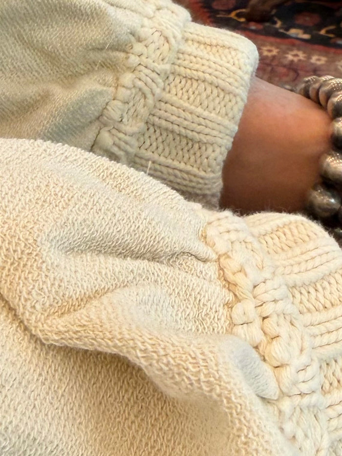 Cream cardigan cuff and hem with chunky knit and cable-like texture