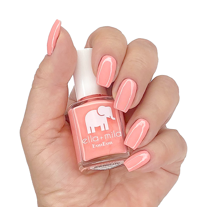 Creamsicle peach pink nail polish manicure on a light skin tone with the bottle