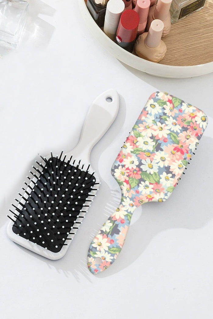 Floral-pattern paddle hair brush with white bristles and cushion base