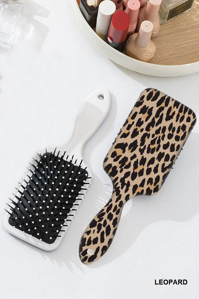 Leopard-print paddle hair brush with white handle and black bristles