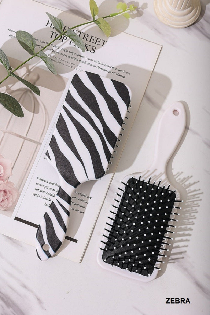 Zebra-print paddle hair brush with white bristles and black cushion pad