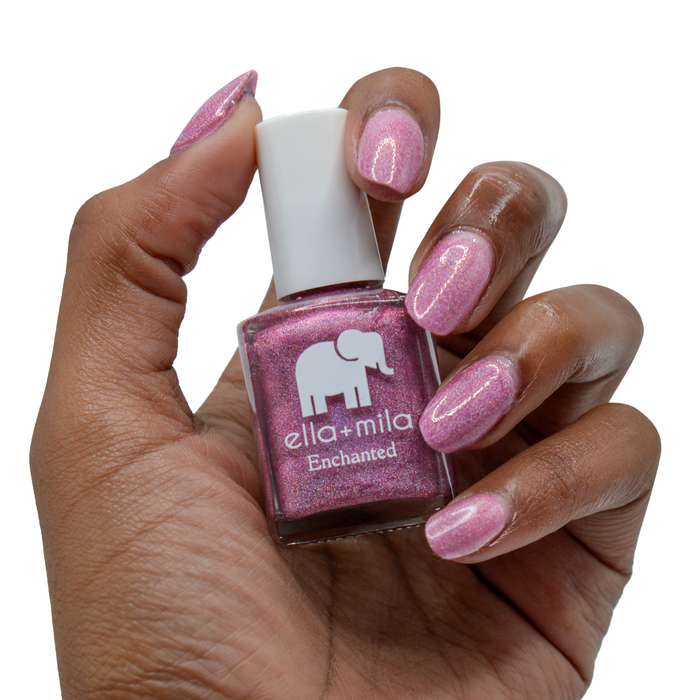 Dragonfly holographic fuchsia nail polish on a deep skin tone, hand holding the bottle