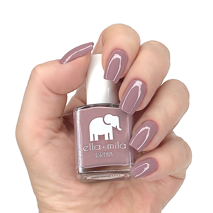Dreamcatcher dusty nude purple nail polish manicure on a light skin tone with the bottle
