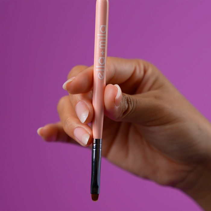 Hand holding the nail art brush end of the dotter tool