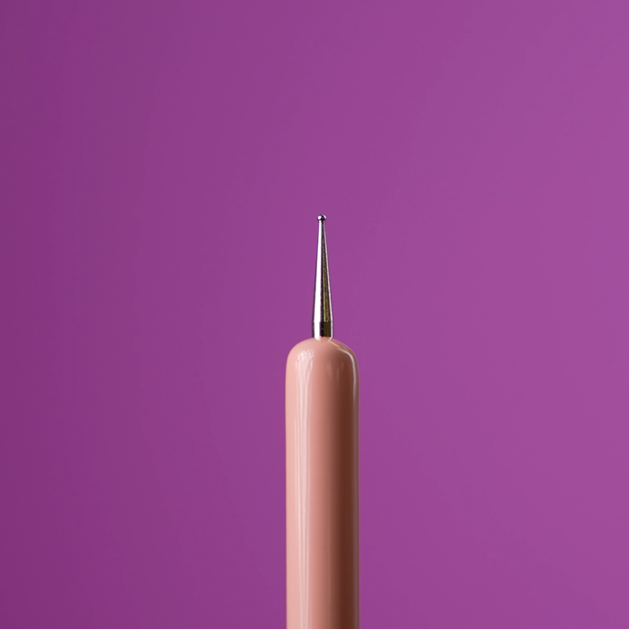 Close-up of the dotting tool tip on a purple background
