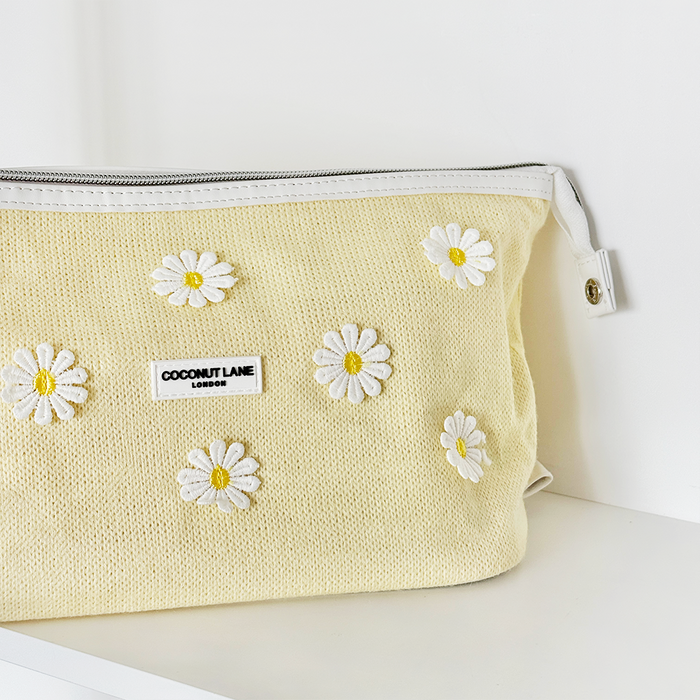 Expandable Buttercup Bloom makeup bag by Coconut Lane in a floral pattern, displayed on a white surface.
