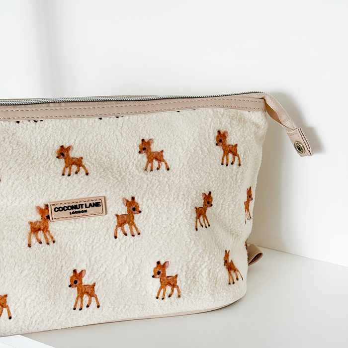 Cream sherpa makeup bag with brown deer print and silver zip.