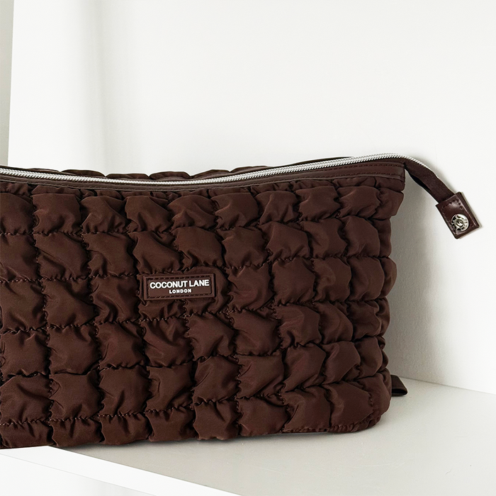 Coconut Lane expandable makeup bag in quilted chocolate brown, displayed on a plain white surface.