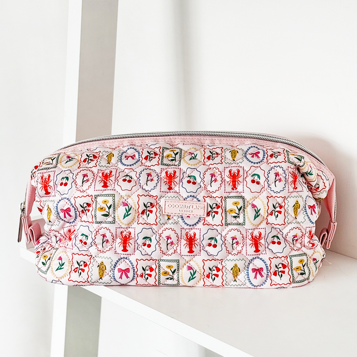 Quilted pink makeup bag with stamped lobsters, flowers, bows, and a pink zipper by Coconut Lane.