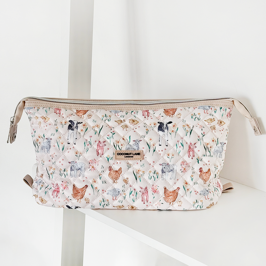 Quilted Coconut Lane expandable makeup bag with colorful animal print sits on a white shelf.