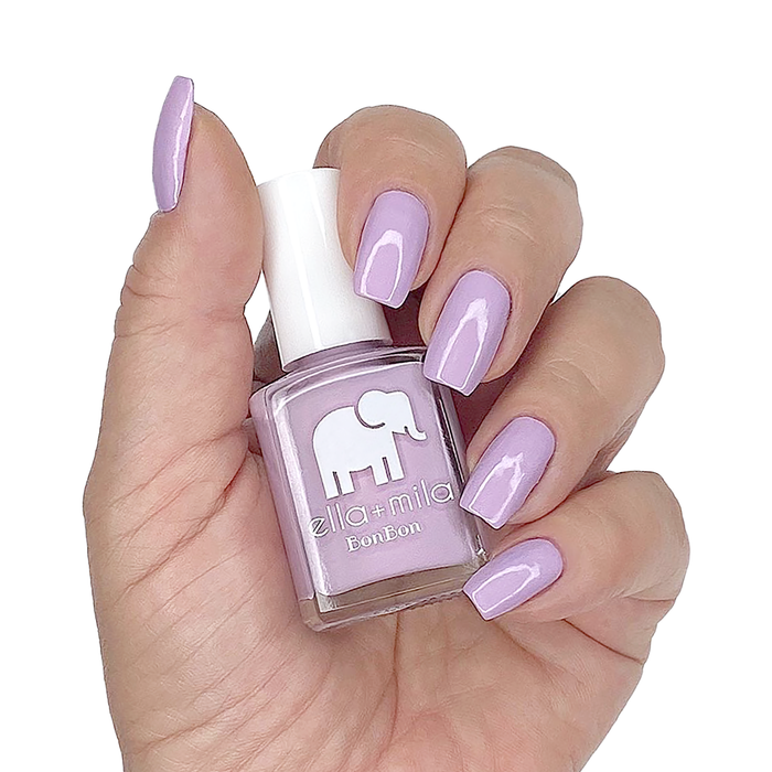Eye Candy light pastel purple nail polish manicure on a light skin tone with the bottle