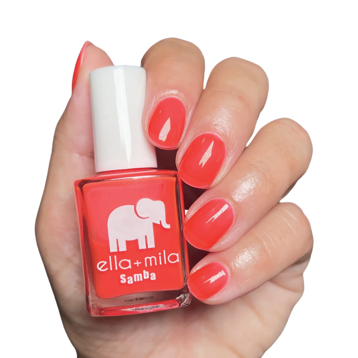French Martini coral nail polish manicure on a light skin tone with the bottle